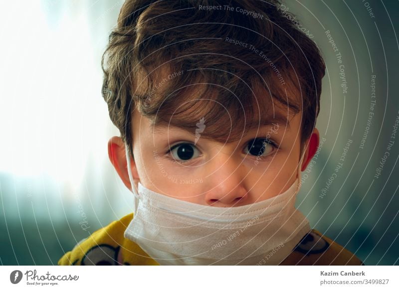 3 years old baby wearing surgical mask peering anxiously at the camera kid corona virus global pandemic epidemic turkey turkish protection curfew prevention