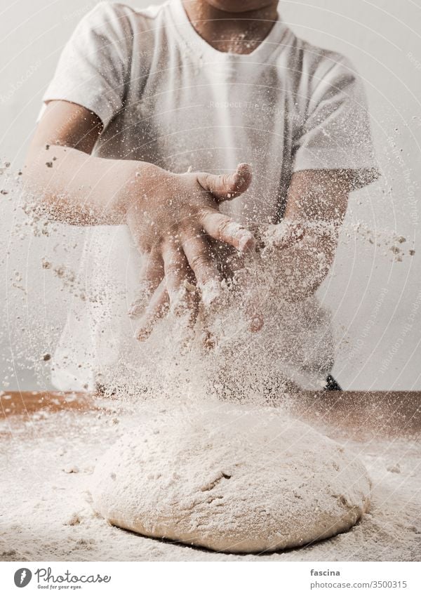 kid clapping hands with flour over dough, vertical crop unrecognizable child person while cooking bread sprinkling white blob story tail food bakery homemade