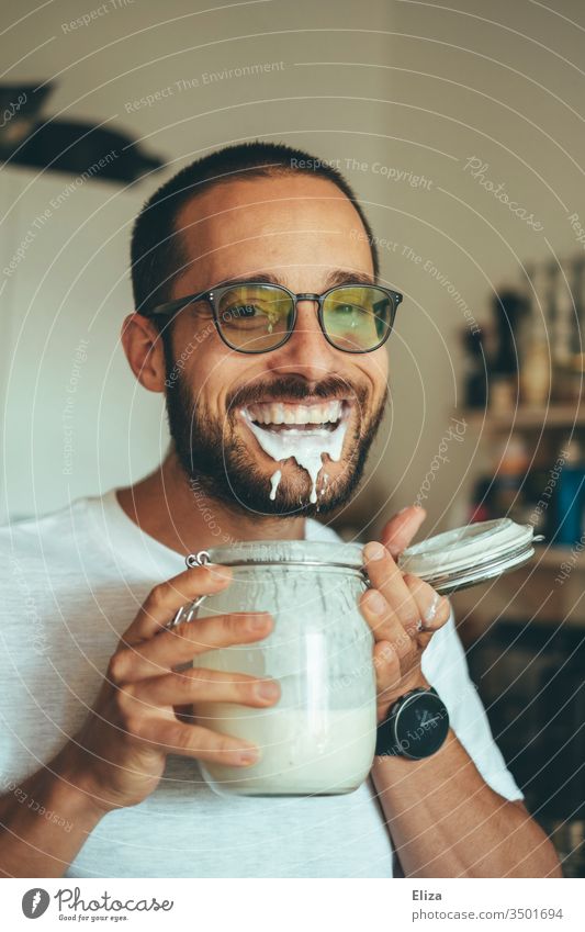 A man is so happy about his homemade kefir full of protein that he only makes nonsense when drinking it and spills it Man Self-made foolish bunkum Drinking