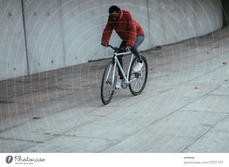 Woman riding bicycle in urban environment cyclist african american on the move lifestyle active transport young eco friendly city city life street young people