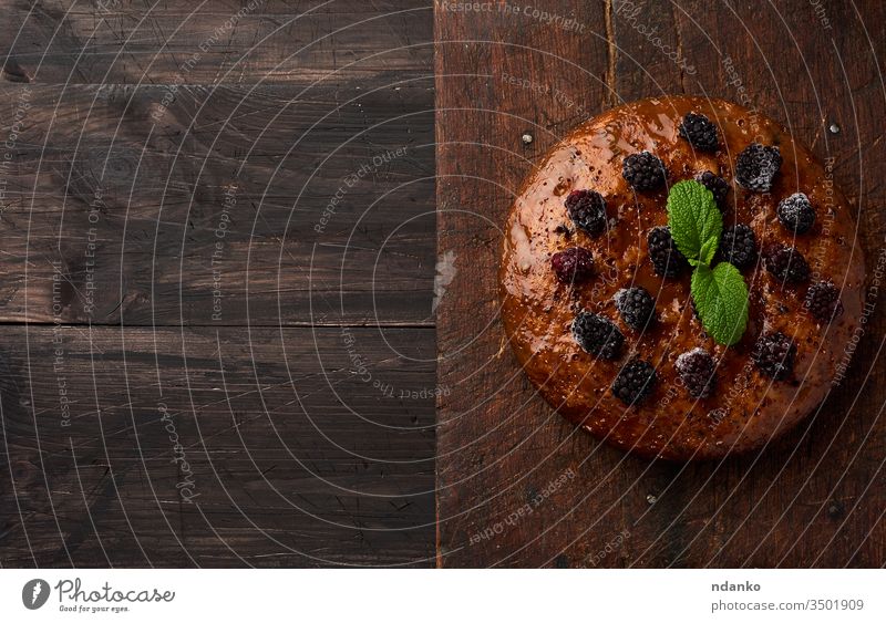 baked round biscuit cake with nuts and berries topped, wooden brown table black bread closeup cook cooking cuisine dark delicious dessert food fresh gourmet