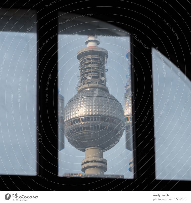 The Berlin TV tower behind an old window alexander Alexanderplatz architecture attraction Background blue broadcast building capital city cityscape