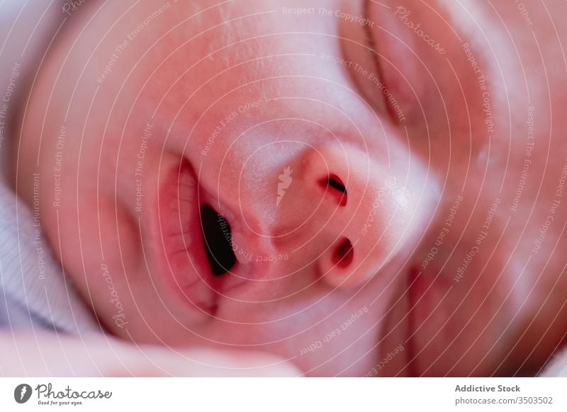 Calm face of small relaxed infant sleeping in soft bed at home newborn baby mouth tranquil kid lip calm nose innocent rest little harmony cute silent peaceful