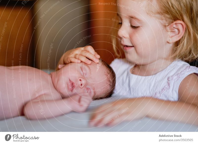 Young sister feeding little newborn brother by milk bottle on bed Stock  Photo - Alamy