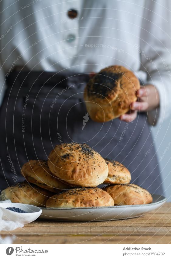 Crop chef with fresh buns bakery poppy plate seed table prepare pastry food delicious tasty meal yummy sweet culinary dish cook snack baked kitchen organic
