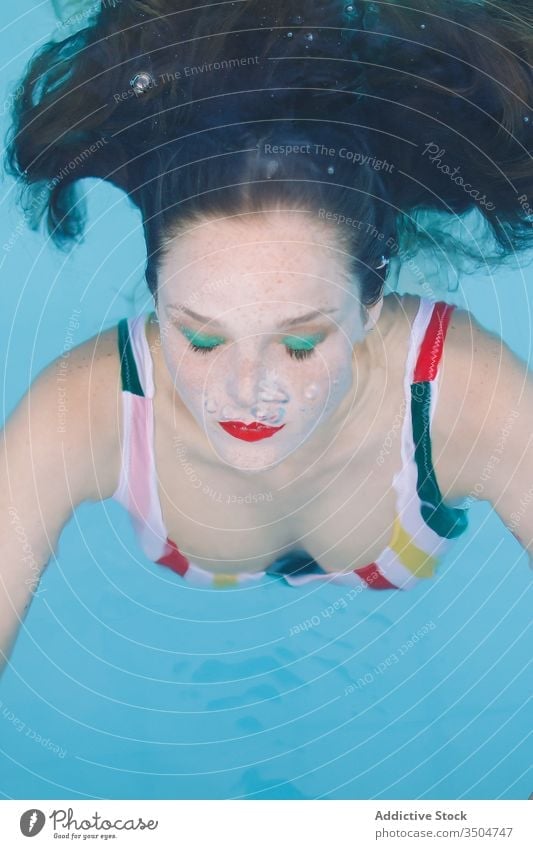 close-up of a brunette girl with hair submerged in the pool with her eyes closed water blue leisure teenager young stairs female woman person summer fun people
