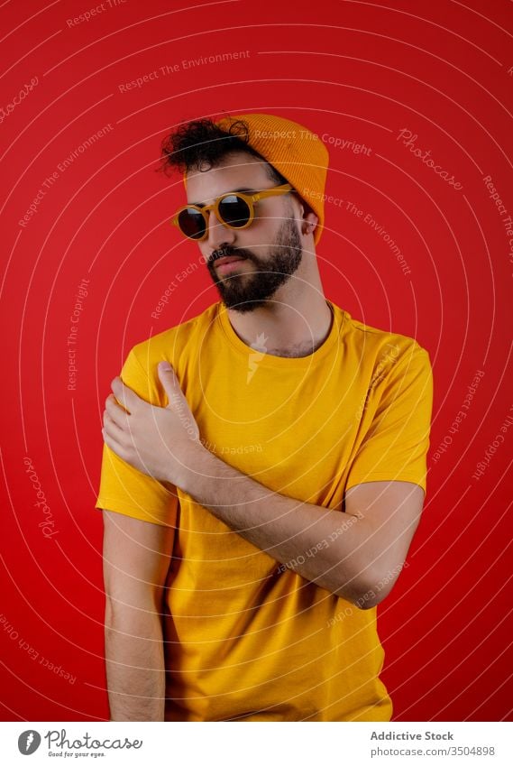 Confident bearded man in trendy outfit style modern urban confident touch shoulder young colorful bright male hipster serious casual yellow fashion cool vibrant