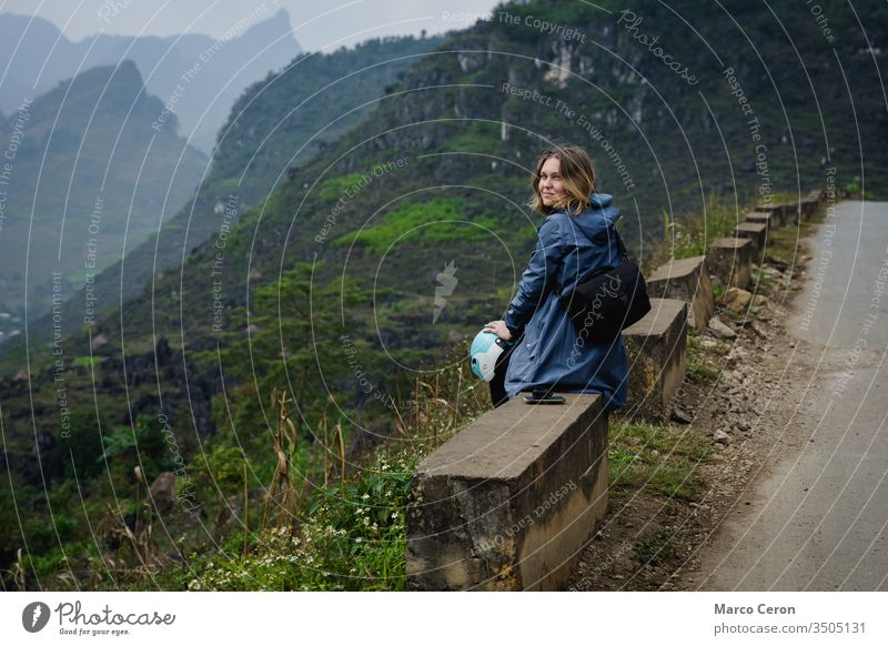 Young woman sitting on the edge of a mountain road, Attractive female bakpacker traveling by motorbike through northern vietnam. person nature lifestyle