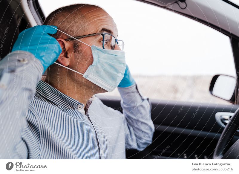 man in a car putting on protective mask and gloves during pandemic coronacirus covid-19 driving coronavirus protective gloves infect automobile health transport