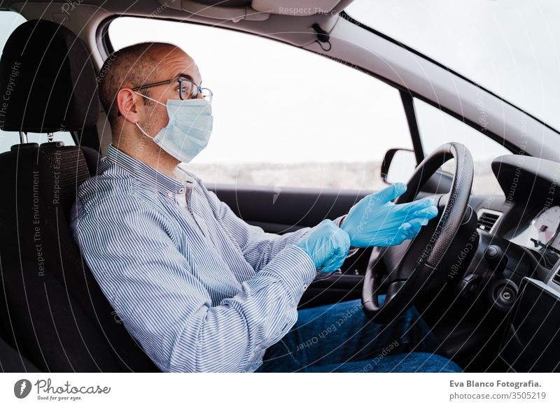 man in a car putting on protective mask and gloves during pandemic coronacirus covid-19 driving coronavirus protective gloves infect automobile health transport