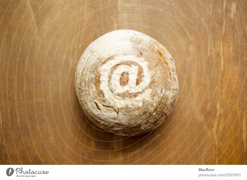At-sign decorated with flour on a bread Bread loaf Baking Baker Bakery pastry food products Round Table wholemeal bread Flour online trading at-sign symbol