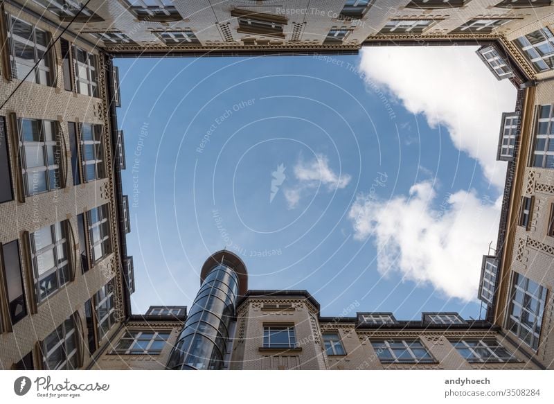 Courtyard of an old house with a cloud apartment architectural architecture atrium blue brick building buildings built built structure city clouds copy space