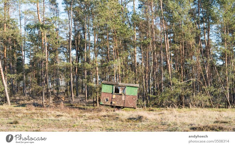 A construction trailer stands on the edge of a forest abandoned aged ancient Background beautiful broken camp camper campsite caravan coniferous damaged decay