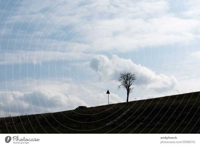 A car alone on the country road adventure automobile beautiful break calm cloud clouds cloudscape drive exploration freedom grass happiness heaven highway hill