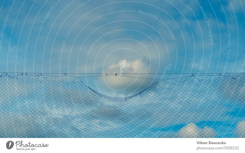 Cloud in the blue sky near the grid barrier background design abstract silhouette border pattern sport football soccer texture nature construction safety mesh