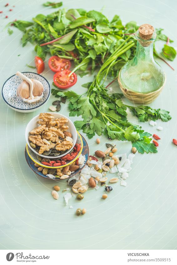Healthy salad making ingredients. Fresh kitchen herbs. Nuts topping. Olives oil. Salad dressing . Diet or vegetarian food concept. healthy fresh nuts olives oil