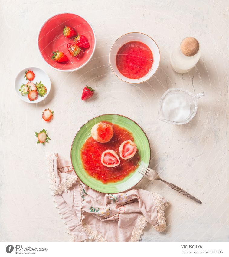 Tasty boiled cottage dumplings stuffed with fresh strawberries. Summer sweet food. breakfast tasty sauce green plate white kitchen table top view summer home