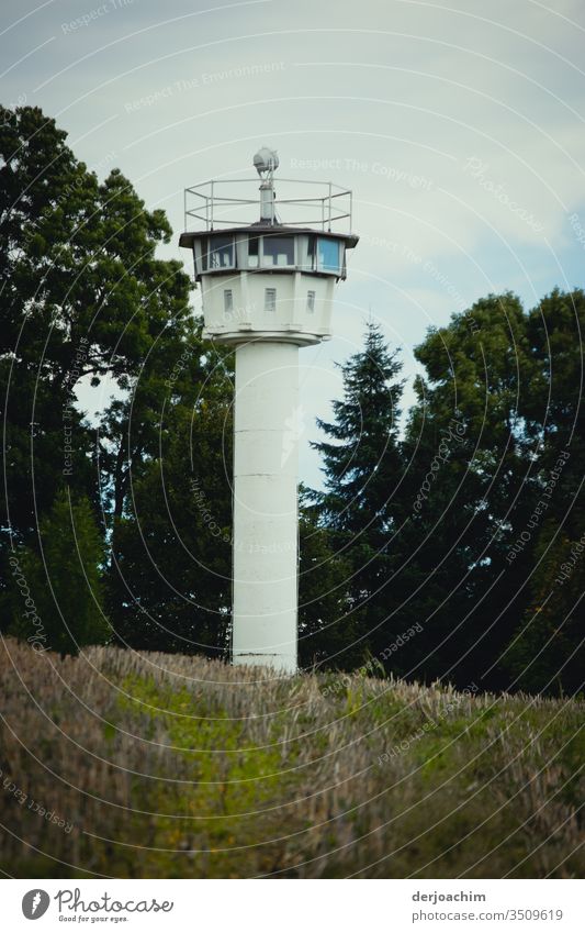 Contemporary witnesses: A white watchtower of the GDR, standing on a meadow. In the background trees. Watch tower Exterior shot Tower Colour photo Deserted