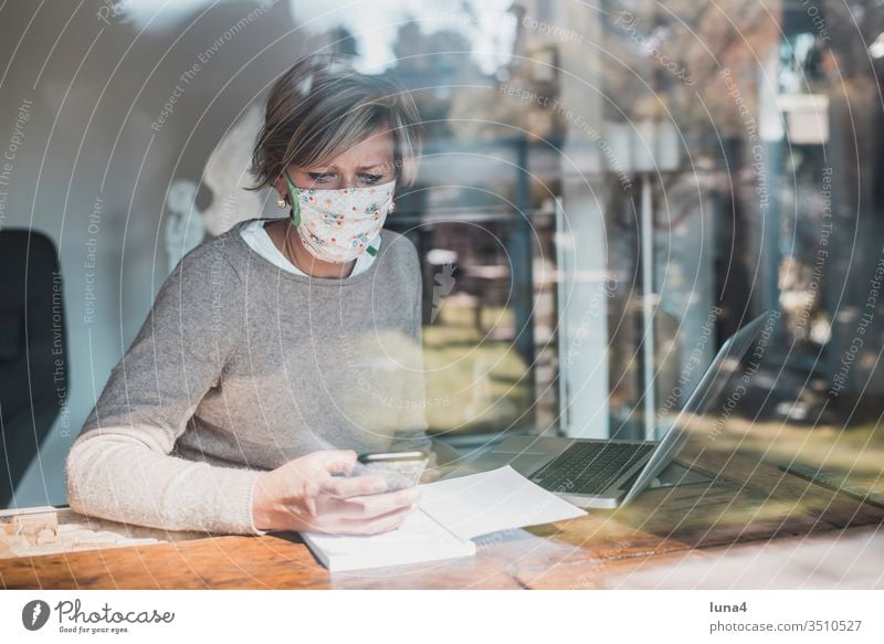 Woman with face mask and smartphone Mask Home Office labour laptop Telephone mobile at home room House (Residential Structure) Blonde Calculator Computer