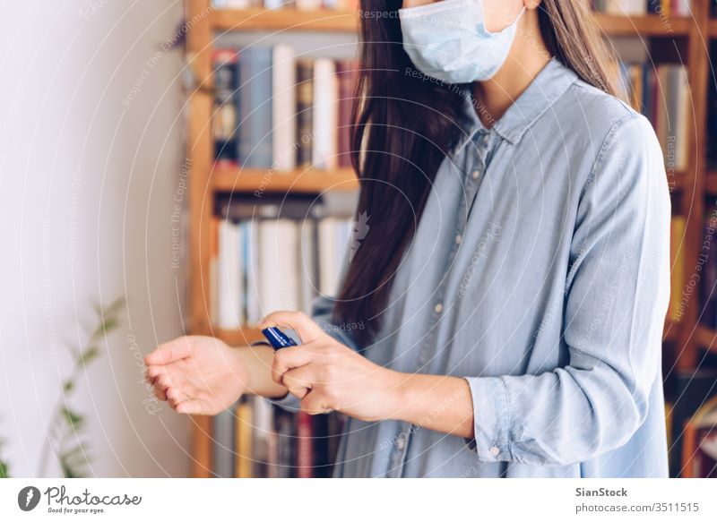 Coronavirus concept. Girl in her home spray with antiseptic her hands for protection from coronavirus. Global call to stay home. covid quarantine gloves