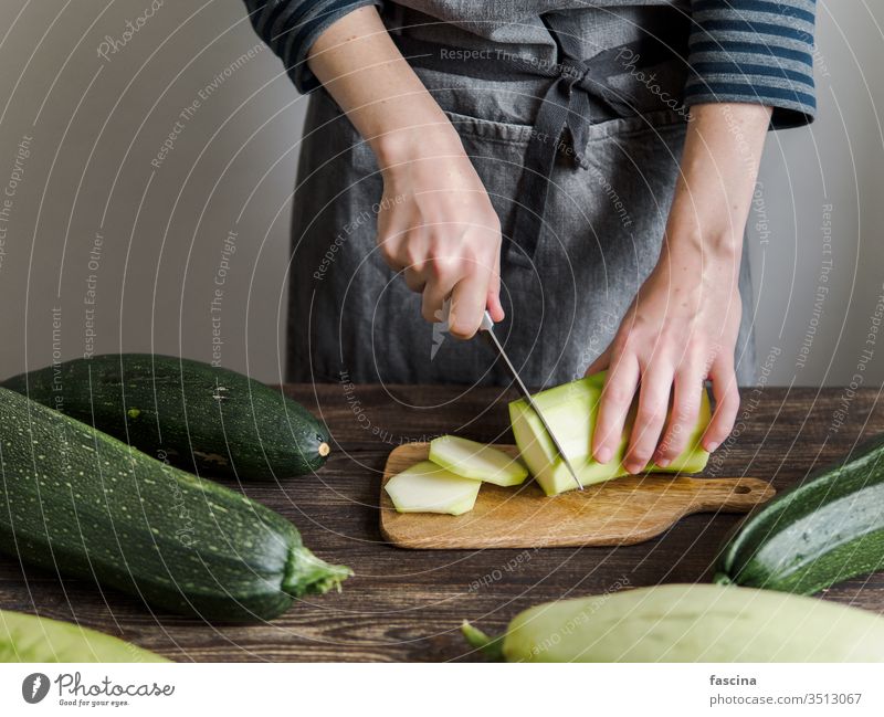 Zucchini harvesting concept. zucchini sliced woman female hand knife cut fresh organic vegetable green ingredient courgette food plant raw summer vegetarian