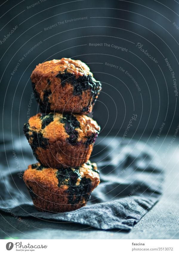 Homemade blueberry muffins on dark background. low calories homemade blueberries muffins three stack nobody top view above vertical food dessert cake snack