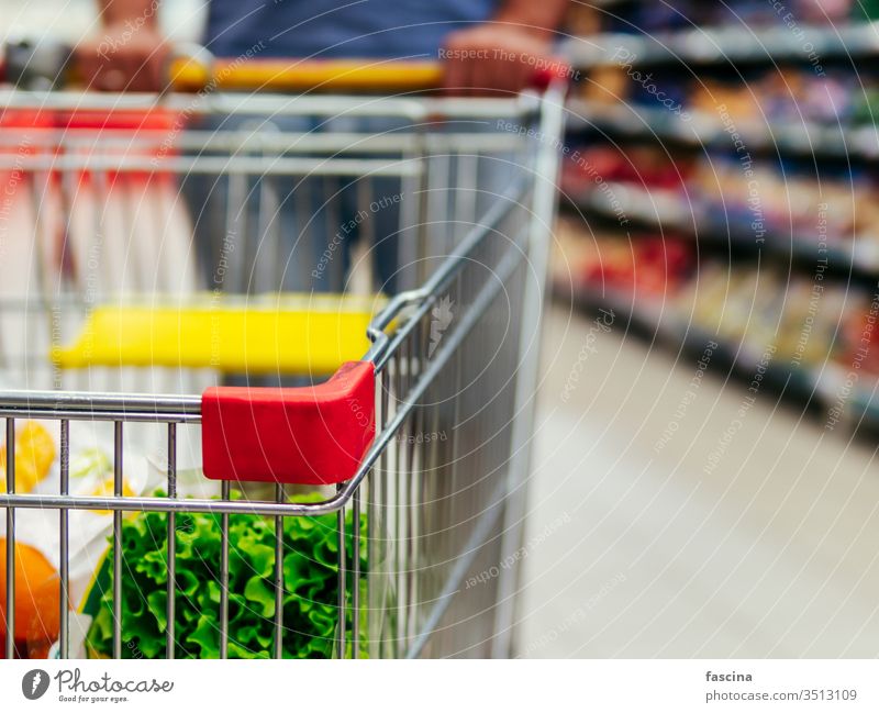 shopping cart in supermarket aisle, copy space trolley grocery man hands latin caucasian hold food store retail shelf customer hypermarket consumer consumerism