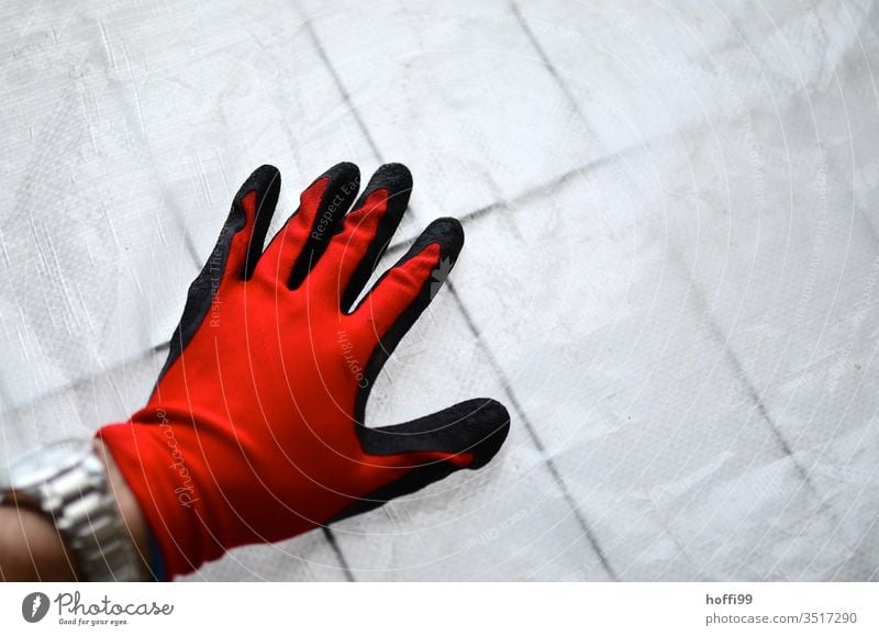 Red glove on construction tarpaulin on the barrier grid Gloves Workwear Protective clothing Work gloves Work and employment Profession Construction site