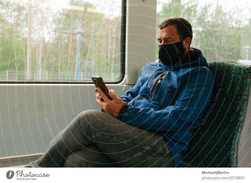 Man with fabric mask or mouth-nose protection in public transport during coronavirus pandemic outbreak Face mask Mask Mouth and nose mask Commuter trains Track