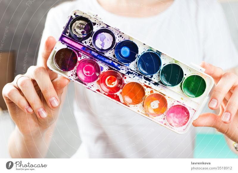 Closeup of woman holding watercolor paints in her hands craft fun creativity artist caucasian closeup colorful concept creative designer drawing education hobby