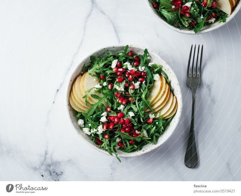 Vegan salad bowl with arugula, pear, pomegranate, cheese vegan healthy dinner food meal green vegetarian marble lifestyle homemade fresh alone plate raw