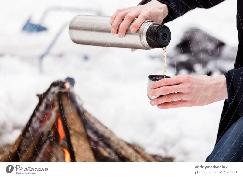 Close-up view of pouring hot tea from thermos into cup Stock Photo