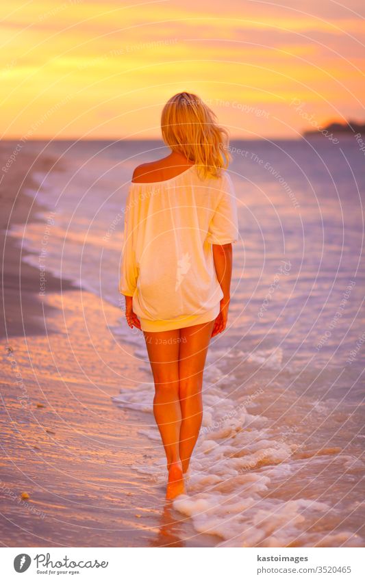 Lady on sandy tropical beach at sunset. woman ocean summer coast joy sea nature lifestyle body young white sexy silhouette person girl lady casual dress