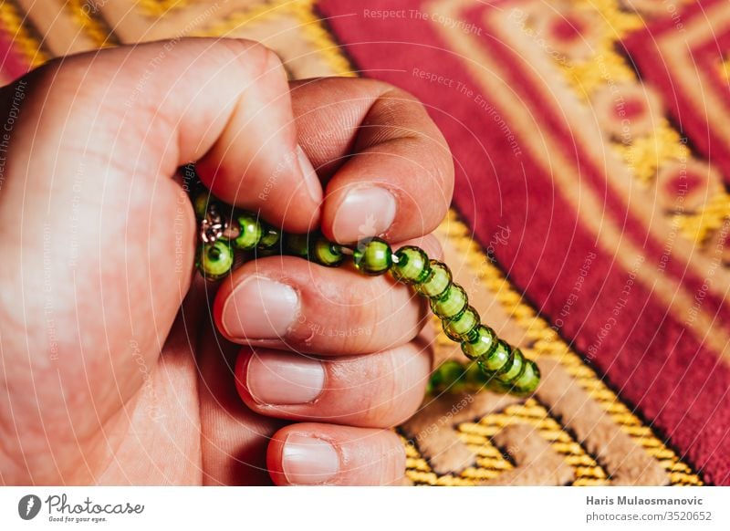 Holding in hand Muslim rosary for prayer on mat in Ramadan Kareem arab arabic art background book culture design dhikr dua east faith fasting friday god green