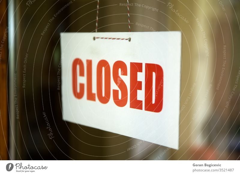 Closed sign board hanging on door of cafe or small store business window shop white street red sorry vintage closed text glass showroom reflections urban signal