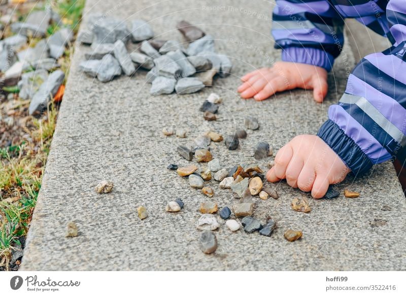 Children's hands sort small stones on a wall children's hands Children`s hand Playing Arrange by hand Infancy Toddler Colour photo Fingers 1 - 3 years Detail