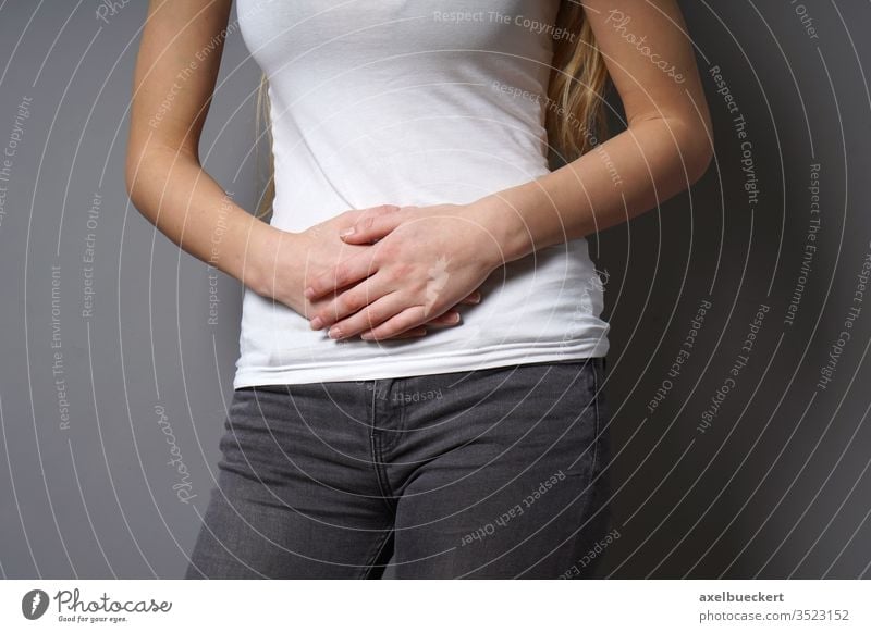 Close Up of Woman in Underwear Holding Stomach in Pain Stock Photo