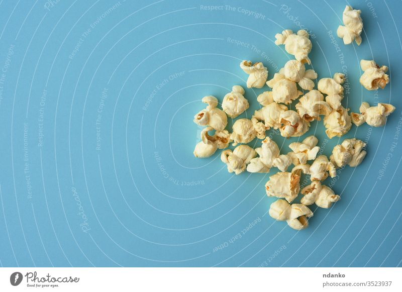 white delicious popcorn on a blue background, a place for an inscription overhead salt salted salty nutrition above classic closeup color crunchy eat fastfood