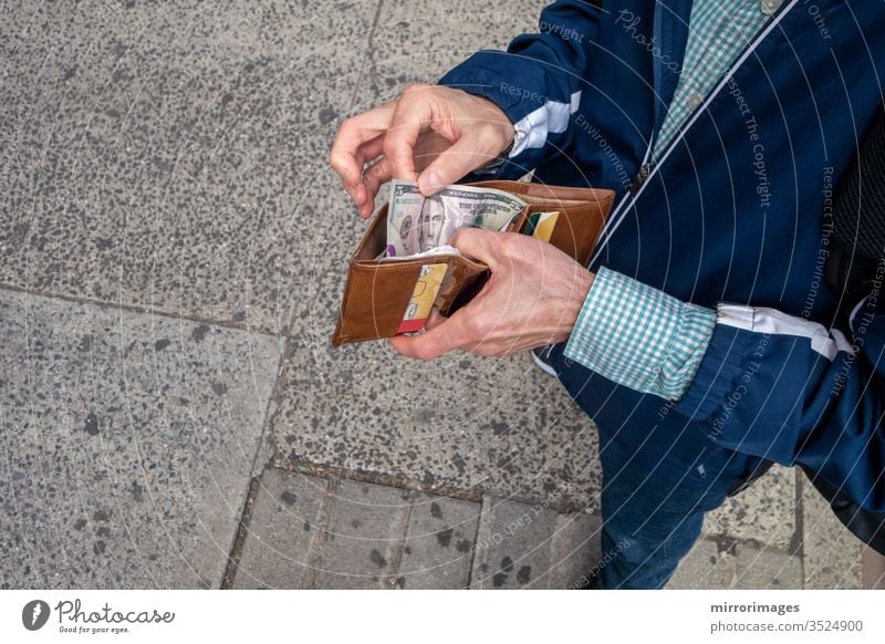 man opeing up his wallet to spend some amercan currency cash paper money business and finance making cash payment economic and payments spending capital