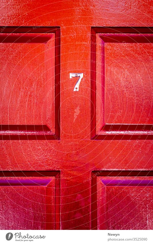 House number 7 on a lucky red wooden front door 7 number address britain burgundy classic classy close up closeup copy space copyspae decoration design detail