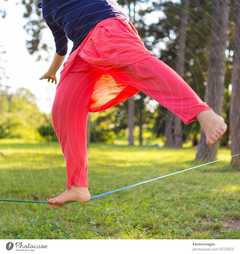 Slack line in the city park. slack line slackline activity sport balance tightrope young person fitness back nature concentration walking outdoors skill one