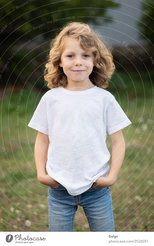 Funny blond kid with long hair child outside one childhood people caucasian joy boy little nature wavy play summer young outdoor fun happy playful lifestyle