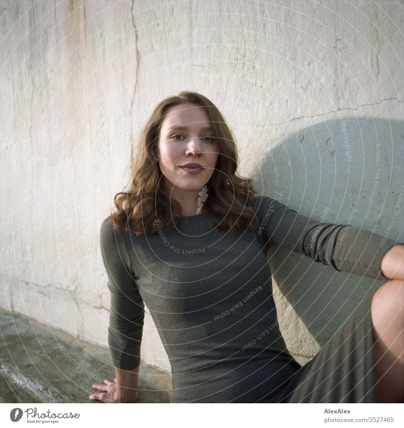 analogue portrait of a young woman in a dress in front of a wall Woman girl already great Athletic Slim fit brunette Curl long hair Wall (building) Concrete