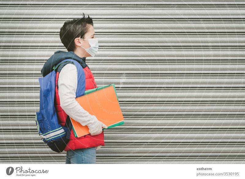 covid-19,kid with medical mask and backpack who walks to school coronavirus child epidemic student pandemic quarantine back to school city schoolboy health