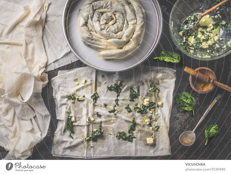 Backing preparation of savory pie with phyllo dough sheets stuffed with spinach and feta cheese . Top view. Balkan or oriental cuisine. Home cooking. Börek