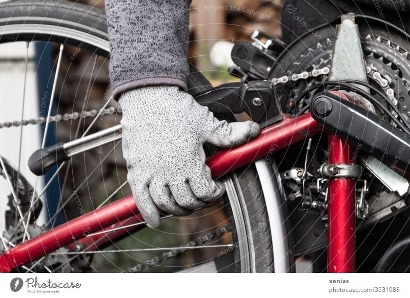 the gloved man's hand grabbed the bicycle after the repair at the frame and turned it around with power and momentum Bicycle Hand Bicycle chain Man
