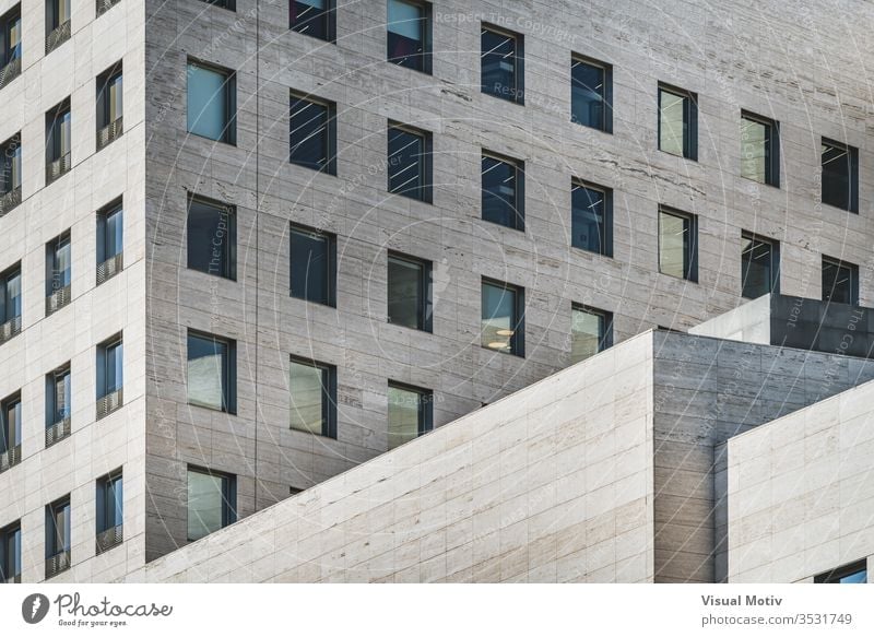 Geometric view of a modern business building built in roman travertine marble facade geometric windows rows glass perspective color outdoor exterior office