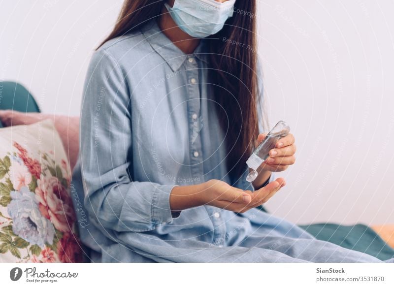 Coronavirus concept. Girl in her home put antiseptic gel on her hands for protection from coronavirus. Global call to stay home. covid quarantine gloves