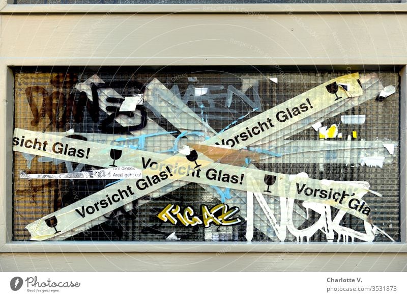 Caution Glass | a broken window pane is held together with "Caution Glass Tape" and additionally embellished by graffiti. Pane Precuation Graffiti Trashy