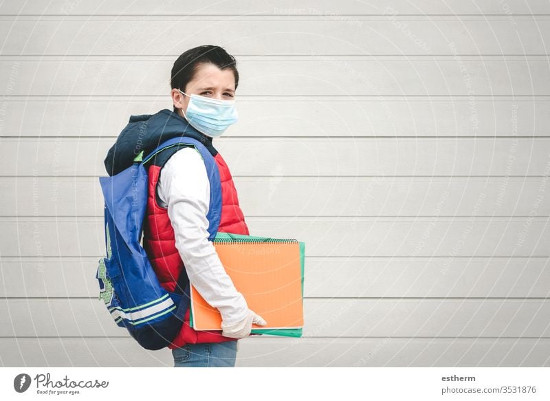 covid-19,portrait of a kid with medical mask and backpack going to school coronavirus child epidemic student pandemic quarantine back to school city schoolboy